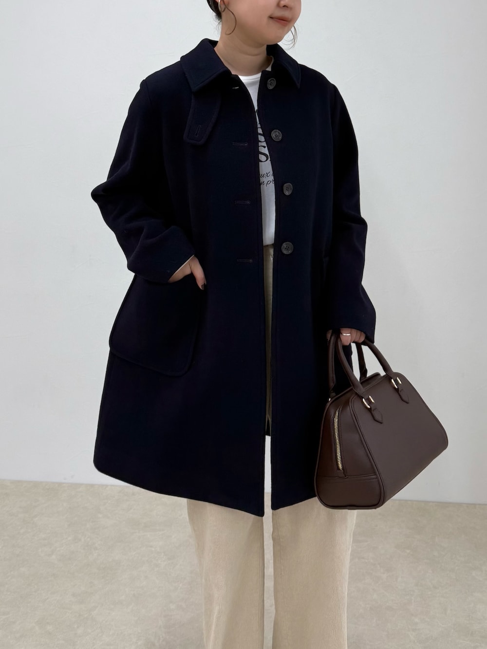 ブルー系のダッフルコート、ベージュ系のその他パンツ、ブラウン系のショルダーバッグを着用したレディースの秋コーディネートの7枚目の写真