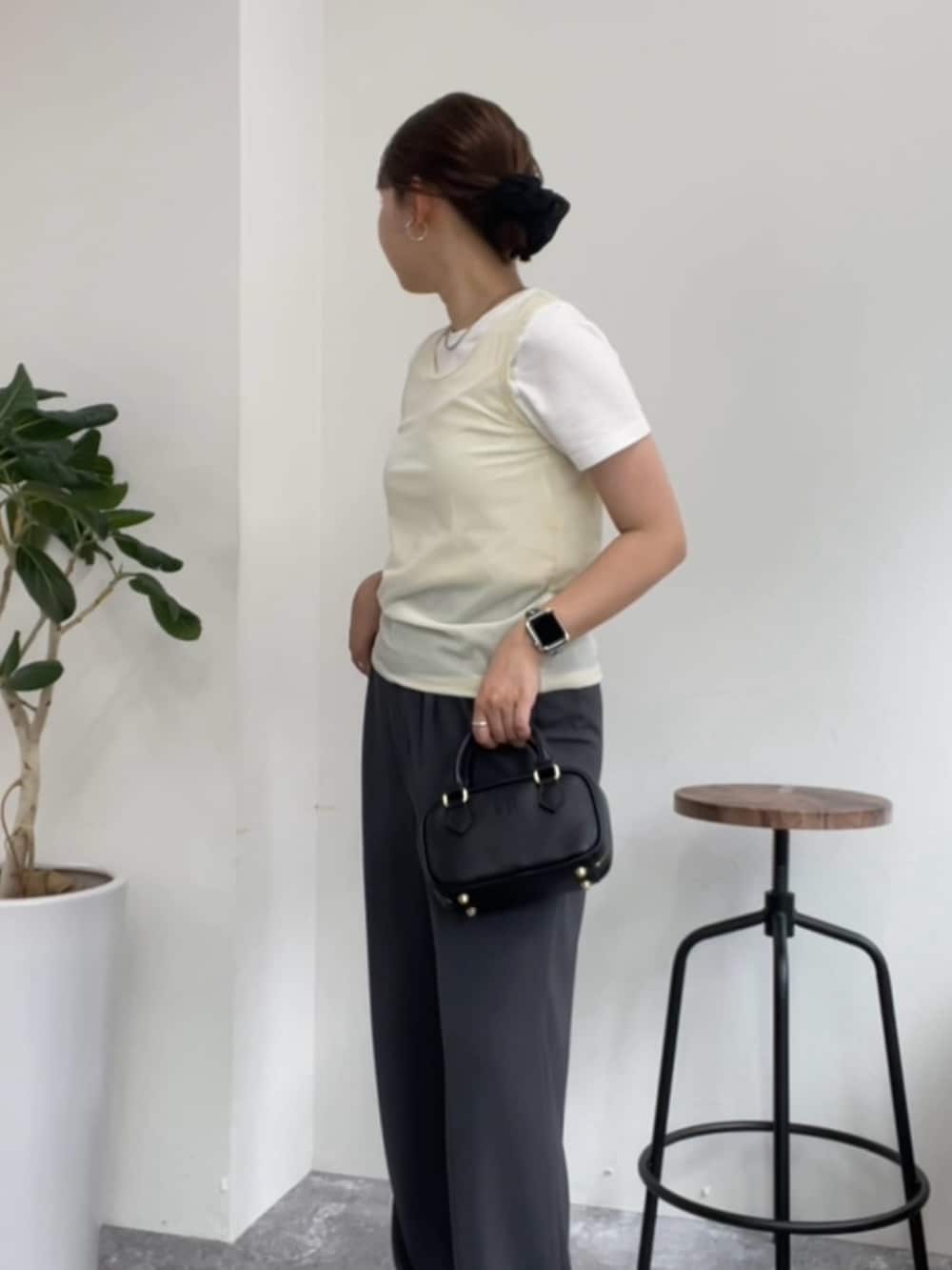 ベージュ系のタンクトップ、ホワイト系のTシャツ/カットソー、グレー系のスラックスを着用したレディースの夏コーディネートの3枚目の写真