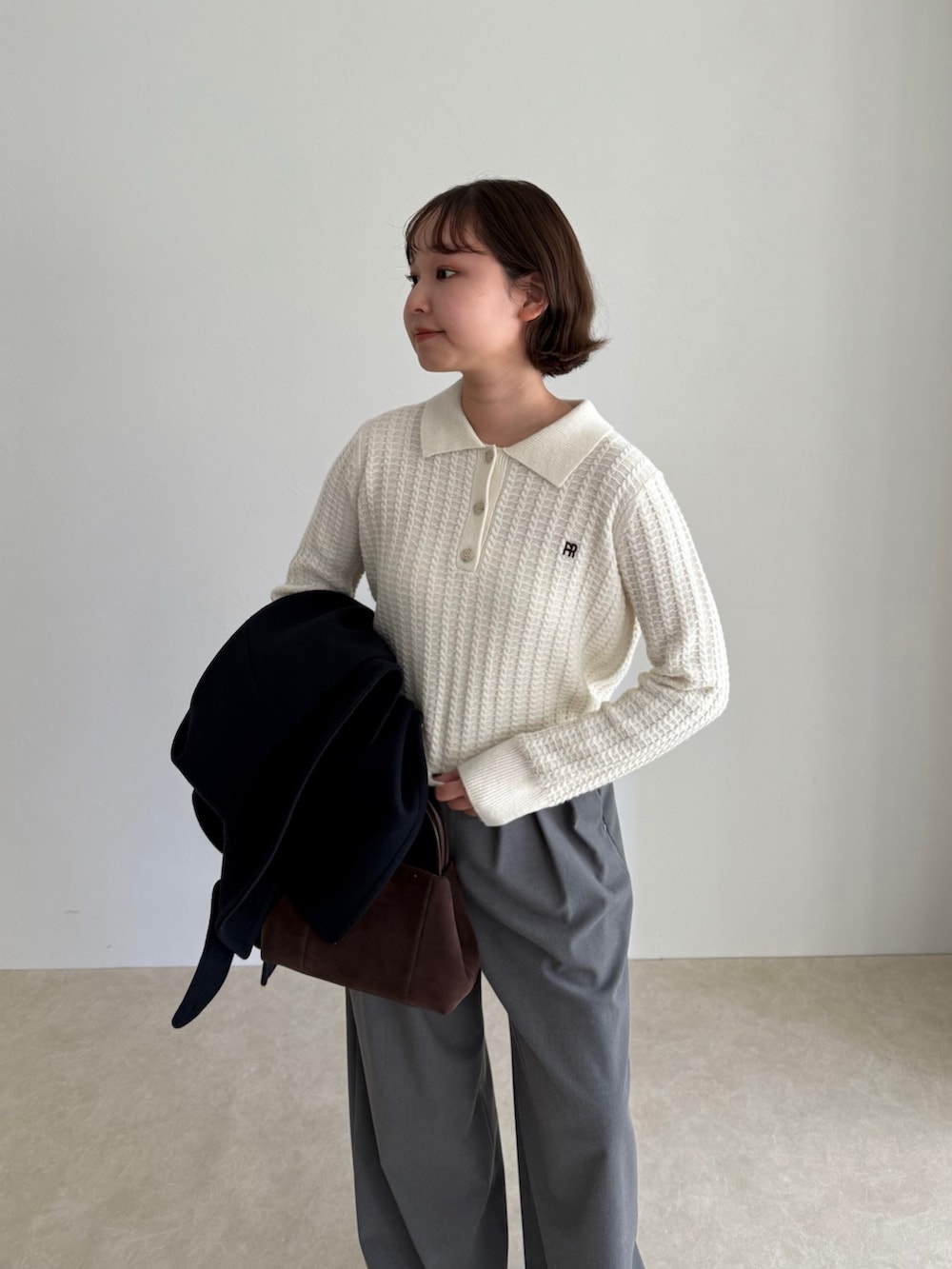 ブルー系のピーコート、グレー系のその他パンツ、ブラウン系のショルダーバッグを着用したレディースの秋コーディネートの6枚目の写真