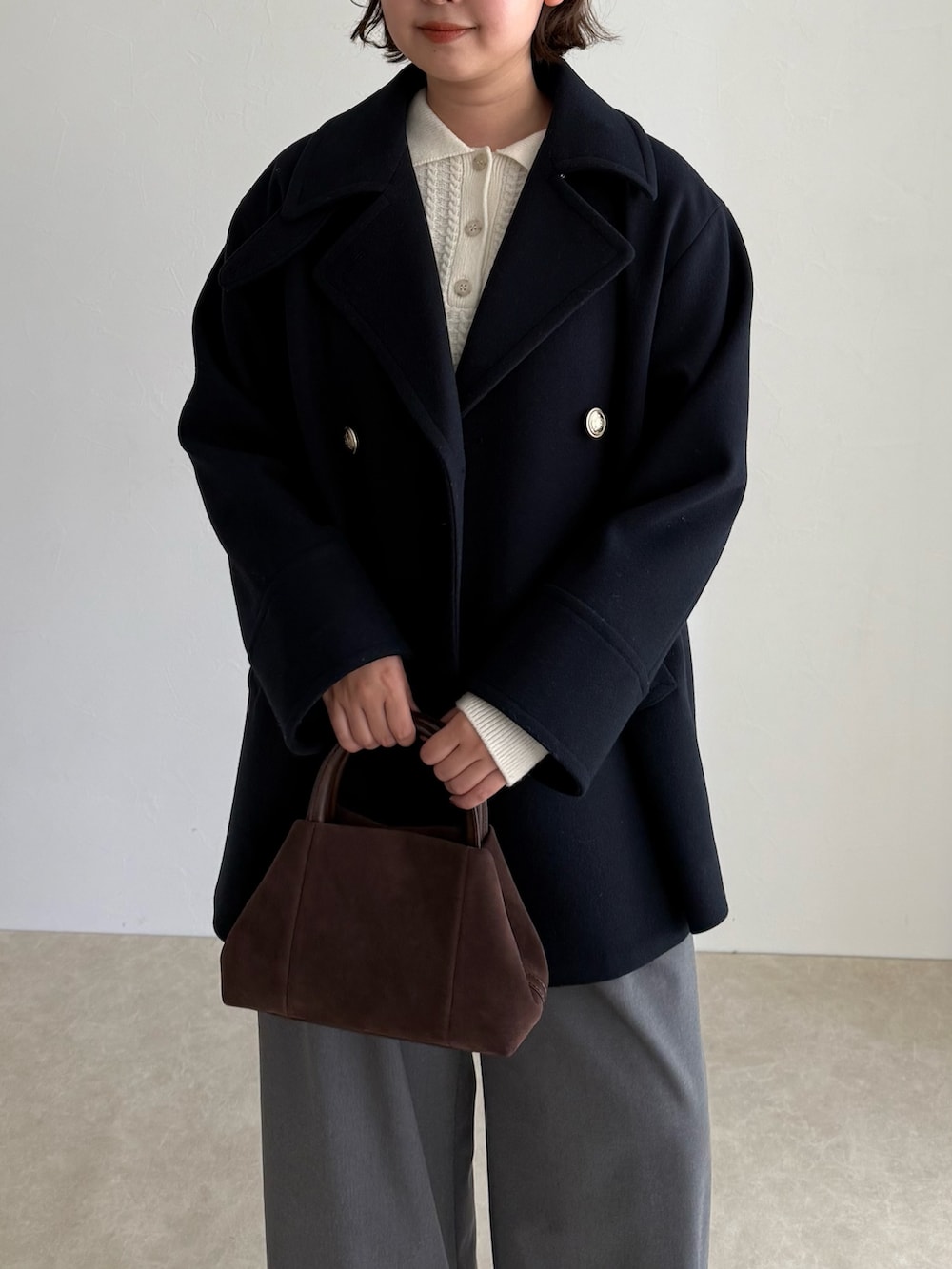 ブルー系のピーコート、グレー系のその他パンツ、ブラウン系のショルダーバッグを着用したレディースの秋コーディネートの7枚目の写真