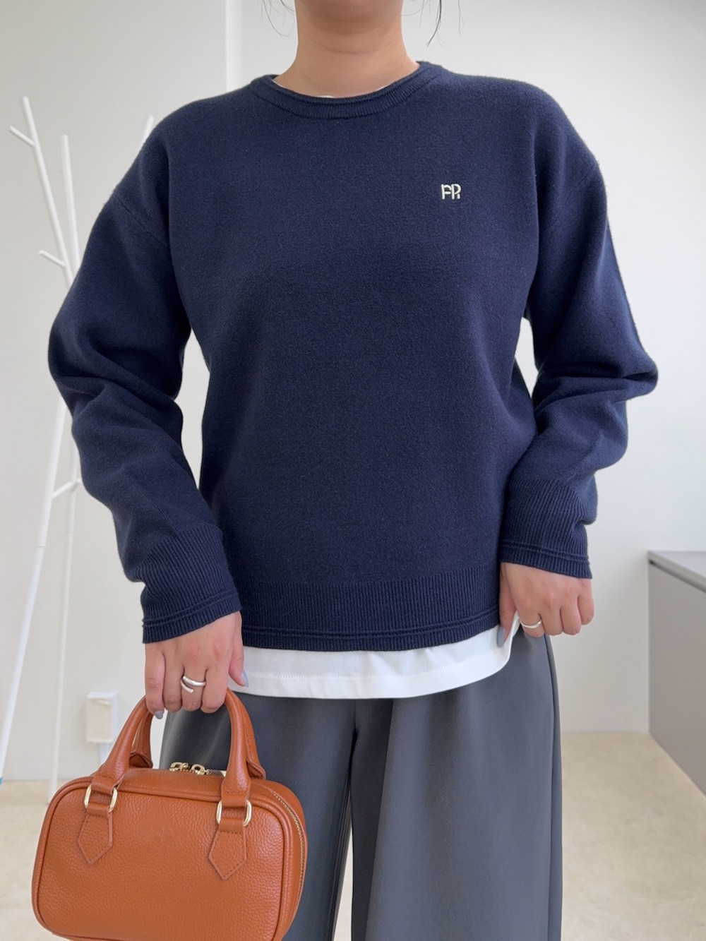 ブルー系のニット/セーター、グレー系のその他パンツ、イエロー系のショルダーバッグを着用したレディースの秋コーディネートの3枚目の写真