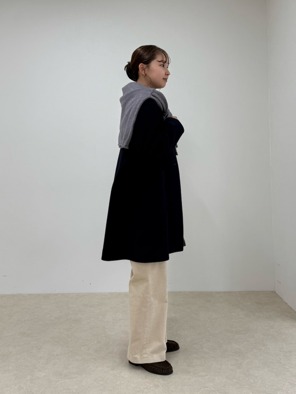 ブルー系のダッフルコート、ベージュ系のその他パンツ、ブラウン系のショルダーバッグを着用したレディースの秋コーディネートの2枚目の写真