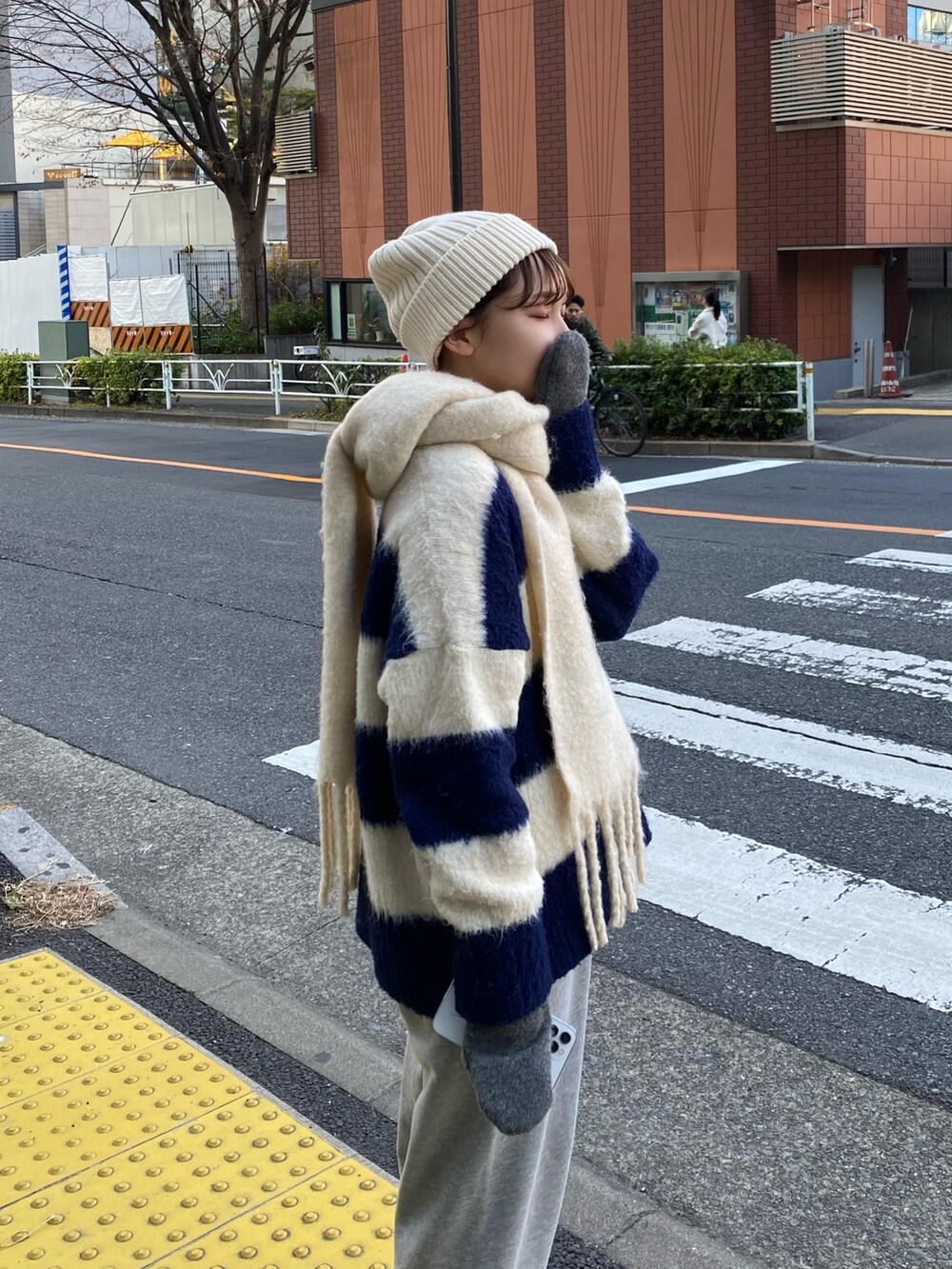 グレー系のスウェットパンツ、ホワイト系のマフラーを着用したレディースの冬コーディネートの5枚目の写真