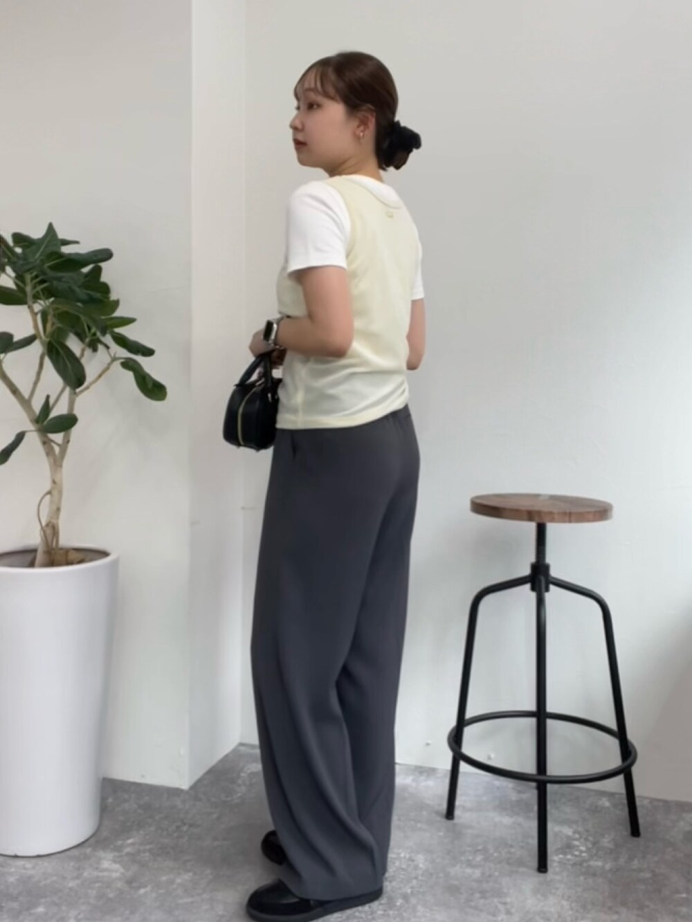 ベージュ系のタンクトップ、ホワイト系のTシャツ/カットソー、グレー系のスラックスを着用したレディースの夏コーディネートの4枚目の写真