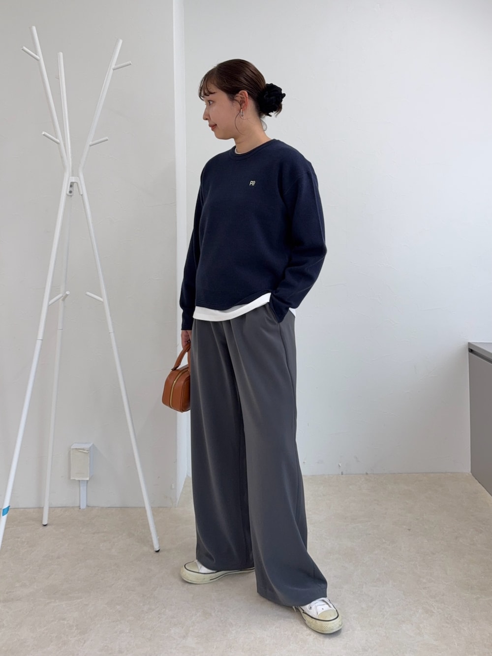 ブルー系のニット/セーター、グレー系のその他パンツ、イエロー系のショルダーバッグを着用したレディースの秋コーディネートの2枚目の写真