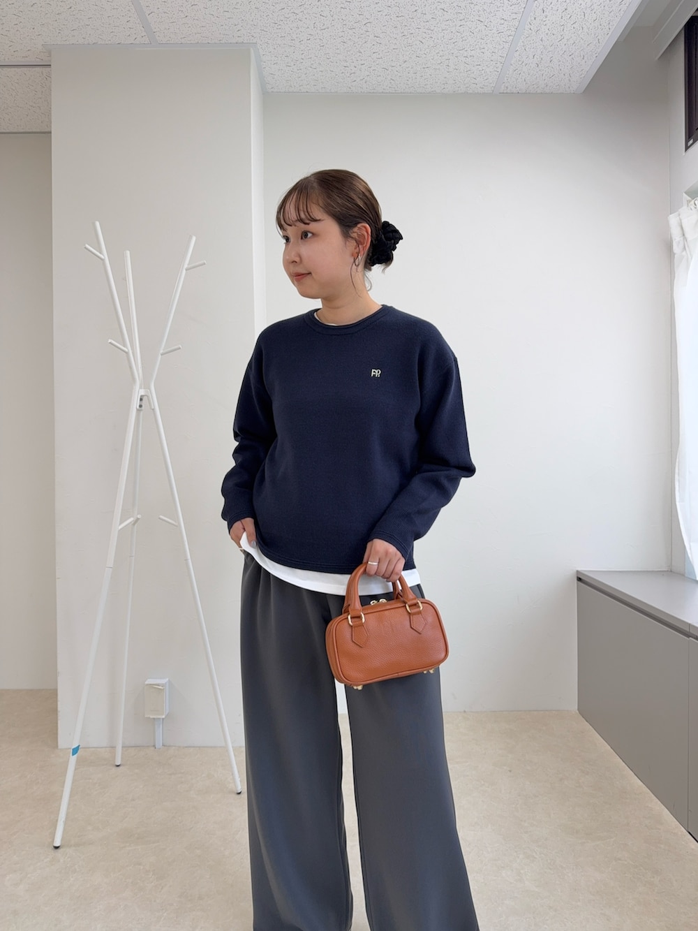 ブルー系のニット/セーター、グレー系のその他パンツ、イエロー系のショルダーバッグを着用したレディースの秋コーディネートの4枚目の写真