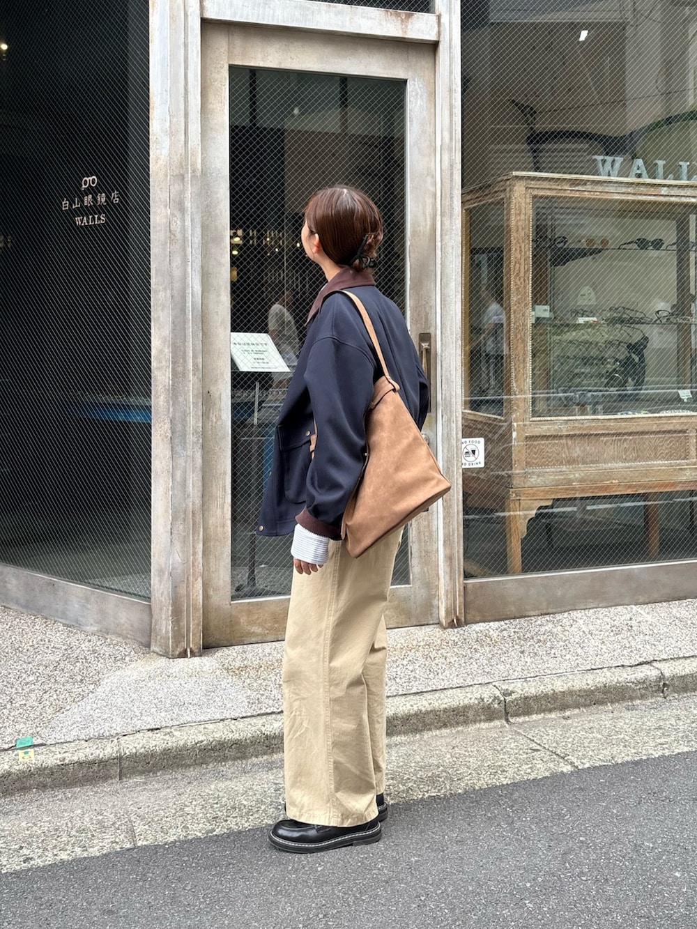 ベージュ系のチノパンツ、ブルー系のブルゾン、ブラウン系のショルダーバッグを着用したレディースの秋コーディネートの4枚目の写真