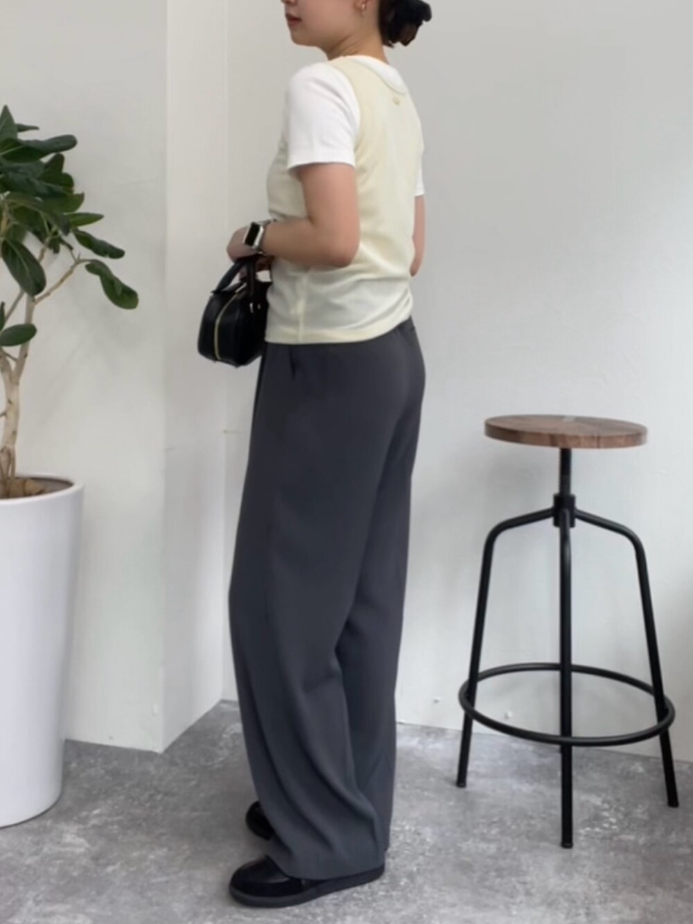 ベージュ系のタンクトップ、ホワイト系のTシャツ/カットソー、グレー系のスラックスを着用したレディースの夏コーディネートの2枚目の写真