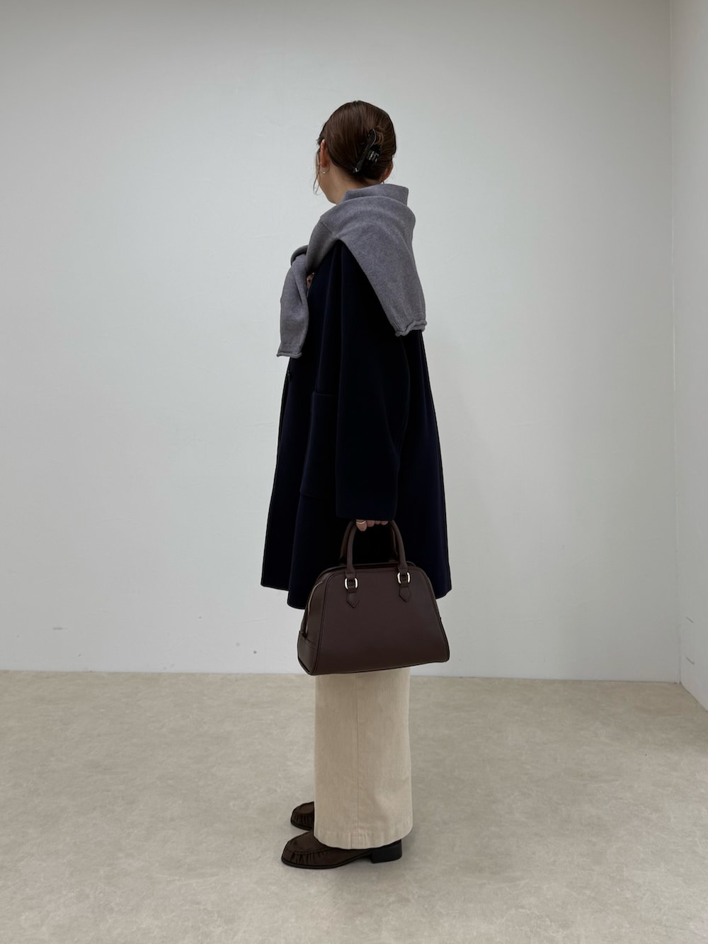 ブルー系のダッフルコート、ベージュ系のその他パンツ、ブラウン系のショルダーバッグを着用したレディースの秋コーディネートの4枚目の写真