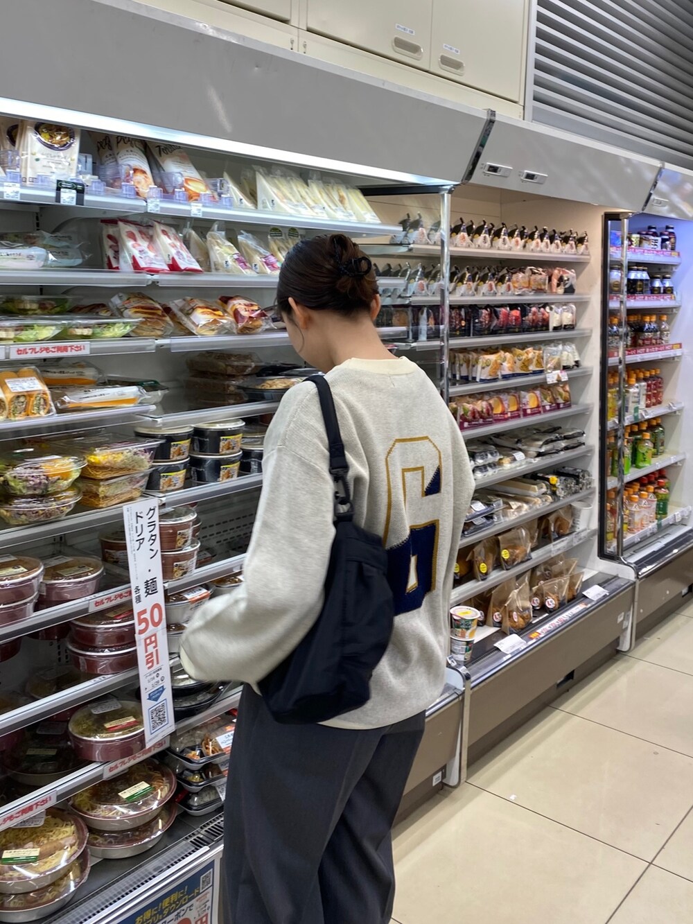 グレー系のその他パンツ、ホワイト系のニット/セーター、ブラック系のショルダーバッグを着用したレディースの冬コーディネートの4枚目の写真