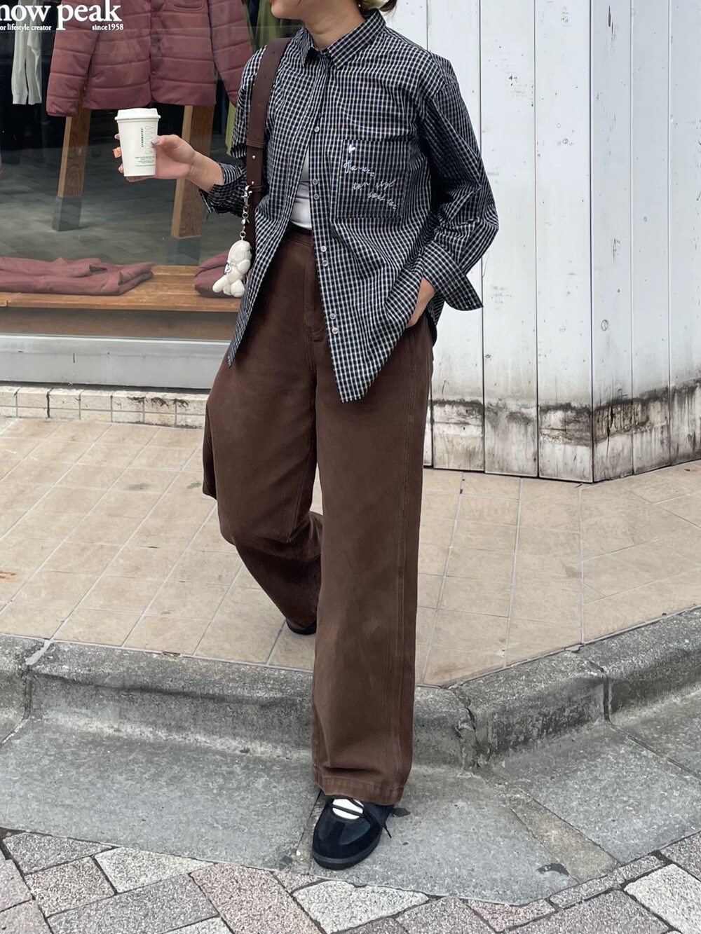 ブラック系のシャツ/ブラウス、ブラウン系のショルダーバッグを着用したレディースの秋コーディネートの4枚目の写真