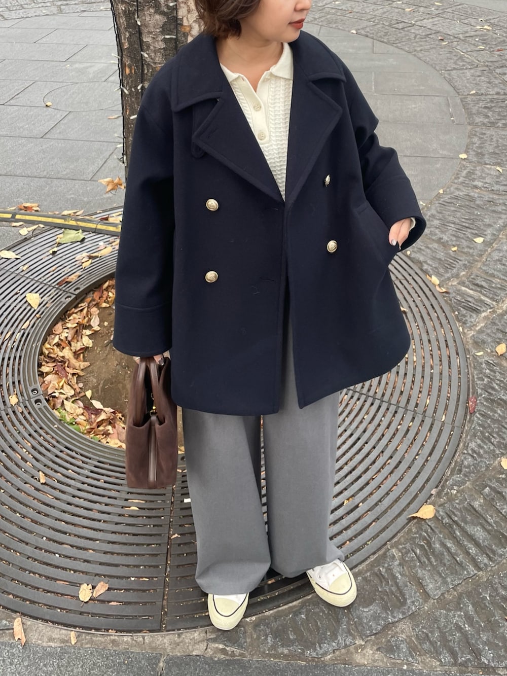 ブルー系のピーコート、グレー系のその他パンツ、ホワイト系のニット/セーターを着用したレディースの秋コーディネートの4枚目の写真