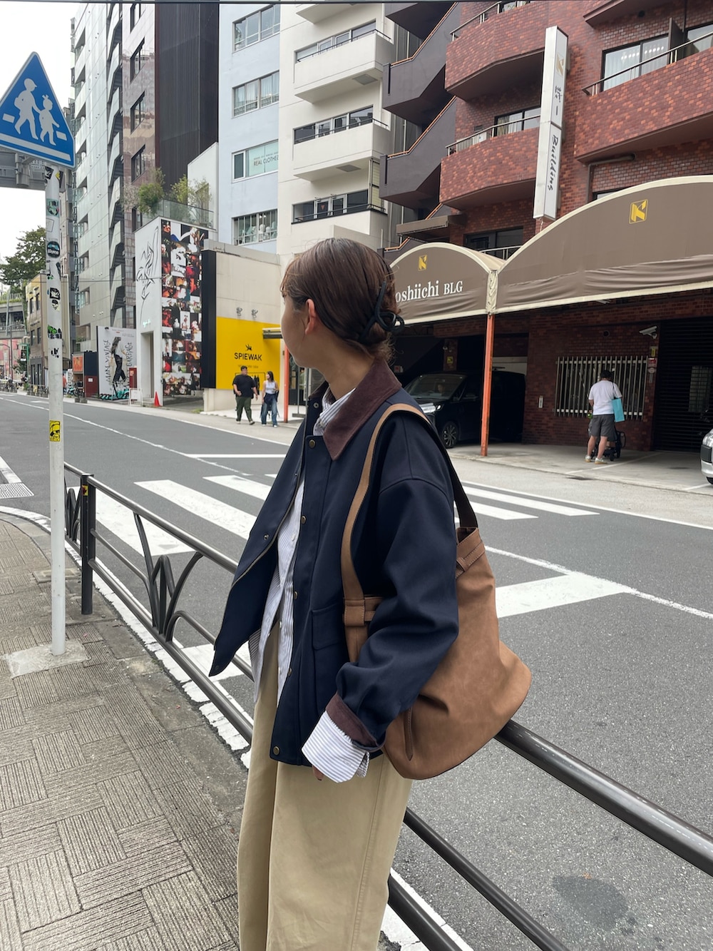 ベージュ系のチノパンツ、ブルー系のブルゾン、ブラウン系のショルダーバッグを着用したレディースの秋コーディネートの2枚目の写真