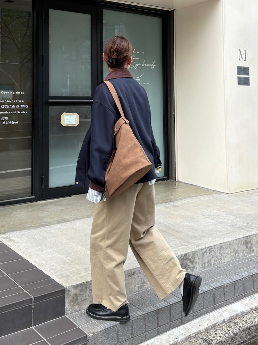 ベージュ系のチノパンツ、ブルー系のブルゾン、ブラウン系のショルダーバッグを着用したレディースの秋コーディネートの6枚目の写真