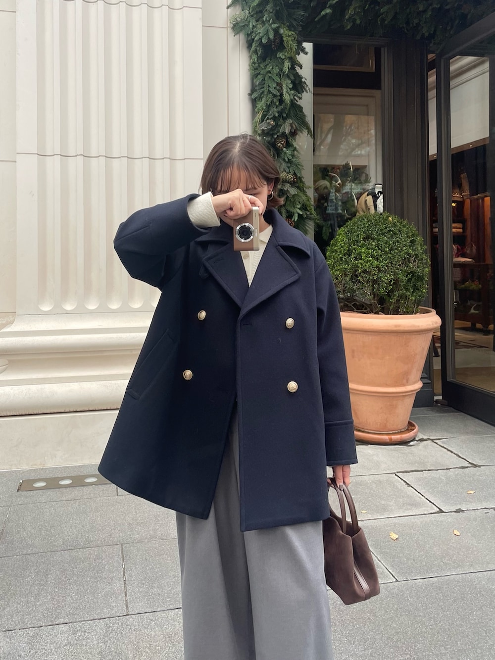 ブルー系のピーコート、グレー系のその他パンツ、ホワイト系のニット/セーターを着用したレディースの秋コーディネートの5枚目の写真