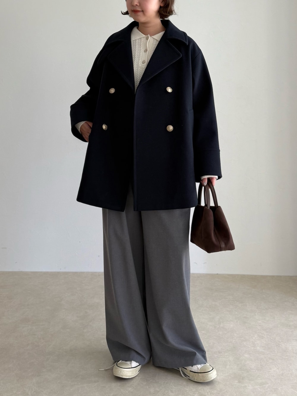 ブルー系のピーコート、グレー系のその他パンツ、ブラウン系のショルダーバッグを着用したレディースの秋コーディネートの2枚目の写真