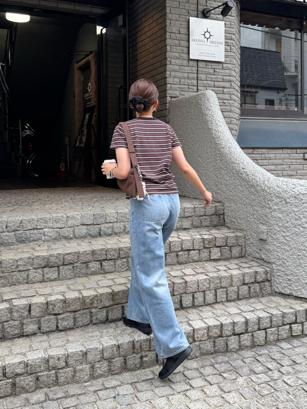 ベージュ系のTシャツ/カットソー、ブラック系のスニーカーを着用したレディースの夏コーディネートの3枚目の写真