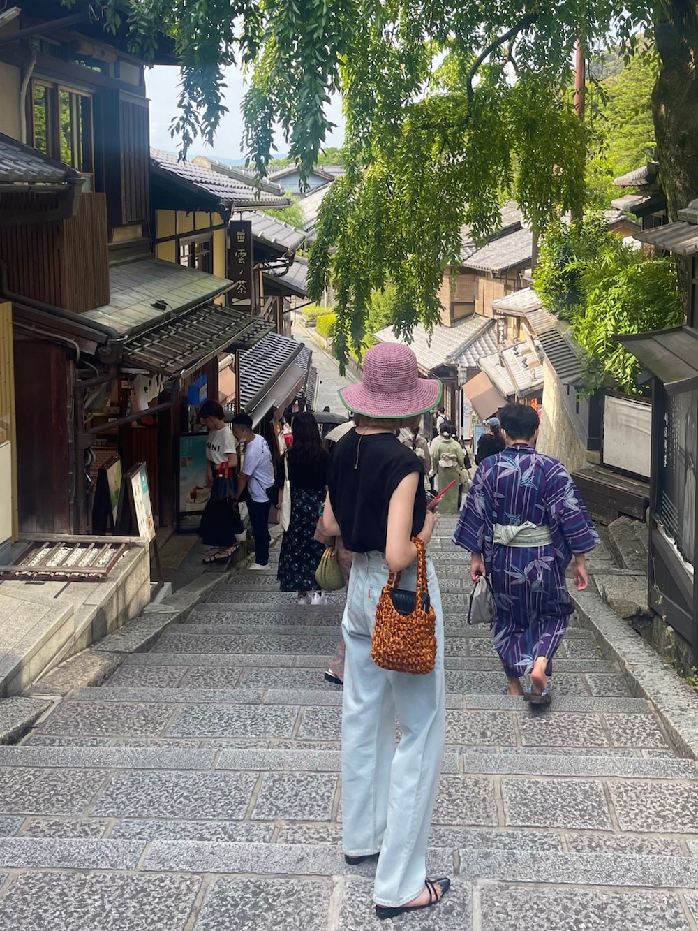 ブラック系のTシャツ/カットソー、イエロー系のハンドバッグ、ブルー系のデニムパンツを着用したレディースの夏コーディネートの2枚目の写真