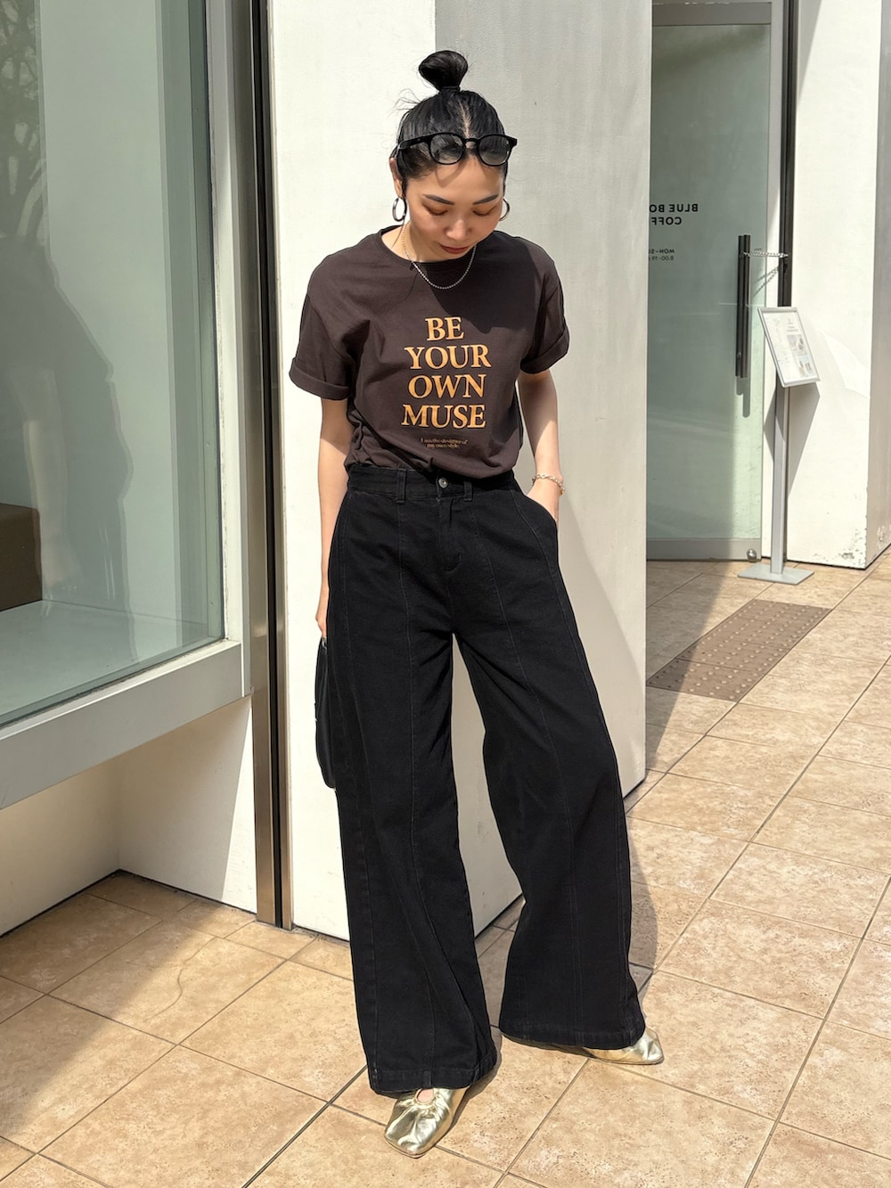 ブラック系のショルダーバッグ、ゴールド系のパンプス、シルバー系のネックレスを着用したレディースの春コーディネートの5枚目の写真