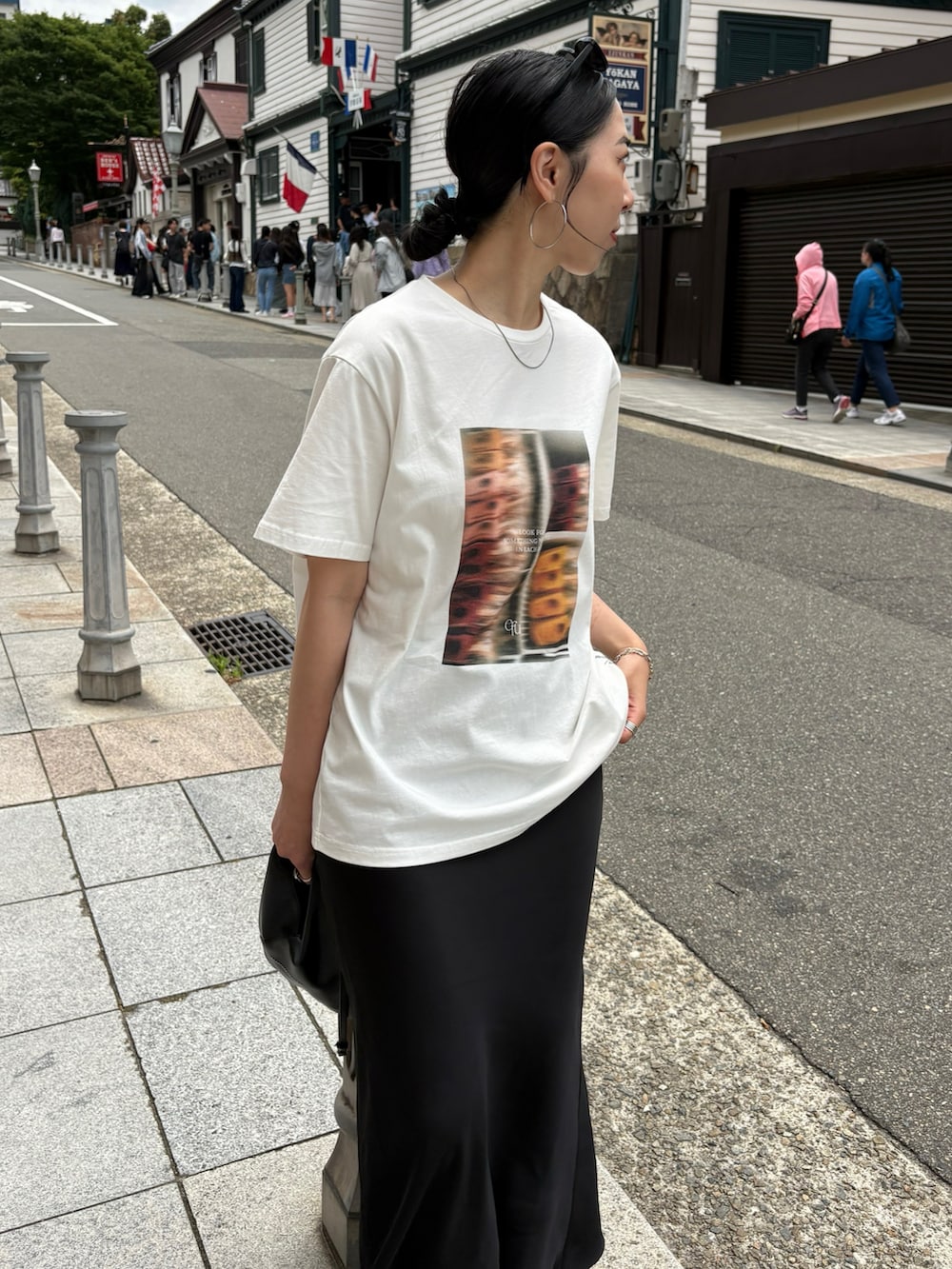 ブラック系のサンダル、ブラック系のショルダーバッグ、シルバー系のネックレスを着用したレディースの夏コーディネートの3枚目の写真