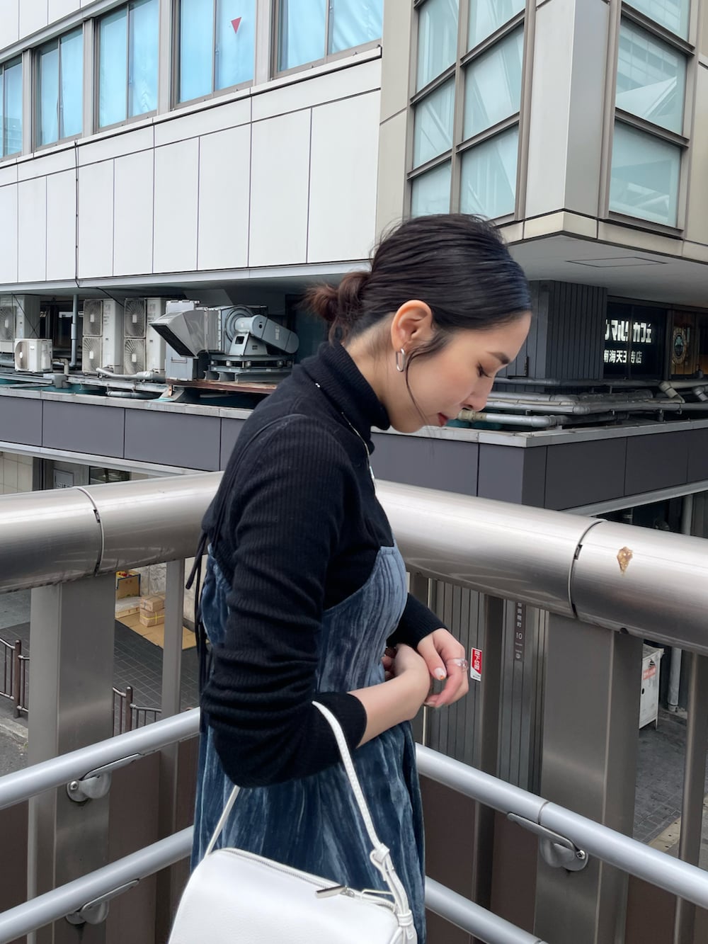 ホワイト系のハンドバッグ、ブルー系のワンピース、ブラック系のニット/セーターを着用したレディースの冬コーディネートの5枚目の写真