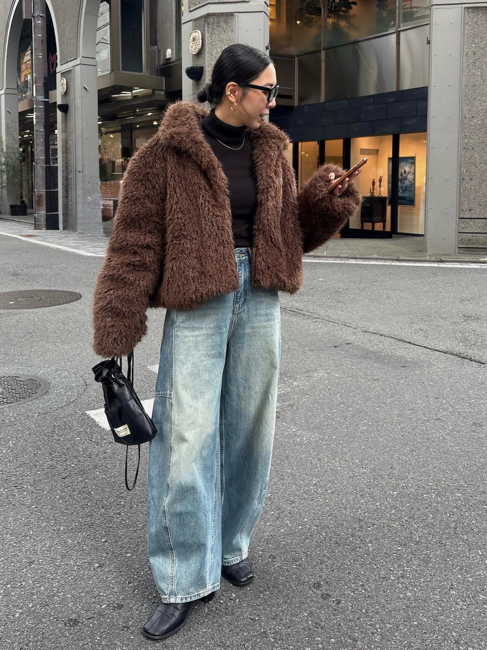 ブラック系のブーツ、ブラック系のショルダーバッグを着用したレディースの秋コーディネートの3枚目の写真