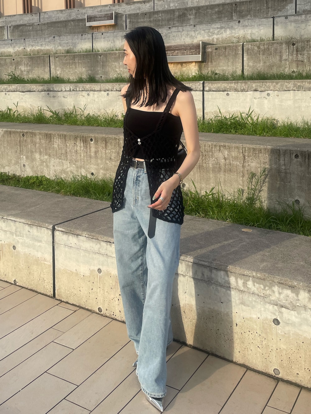 ブルー系のデニムパンツ、ブラック系のショルダーバッグ、ブラック系のキャミソールを着用したレディースの夏コーディネートの4枚目の写真