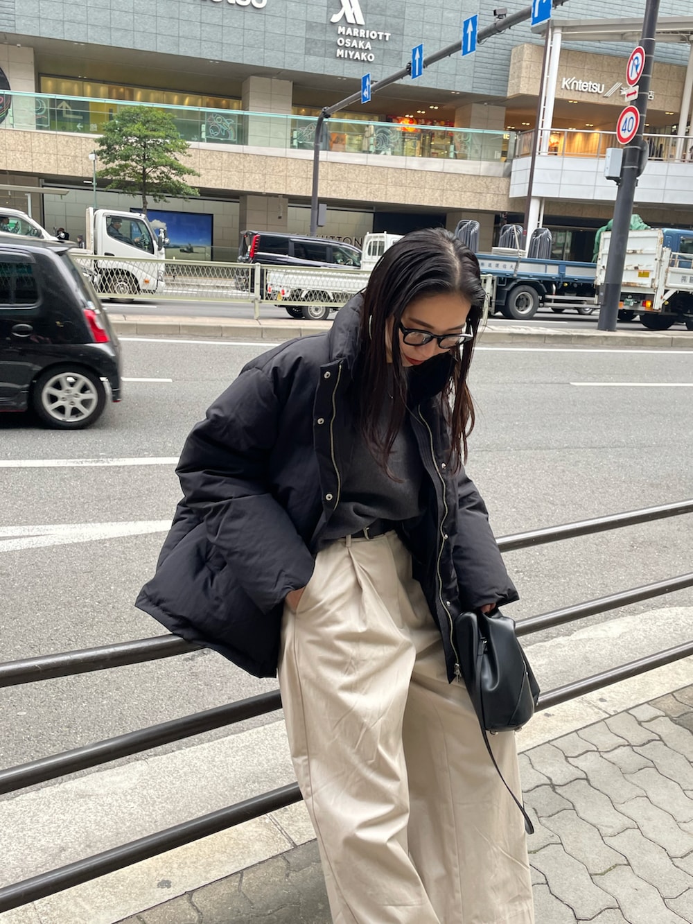 ブラック系のショルダーバッグ、ホワイト系のその他パンツ、ブラック系のダウンジャケット/コートを着用したレディースの冬コーディネートの4枚目の写真