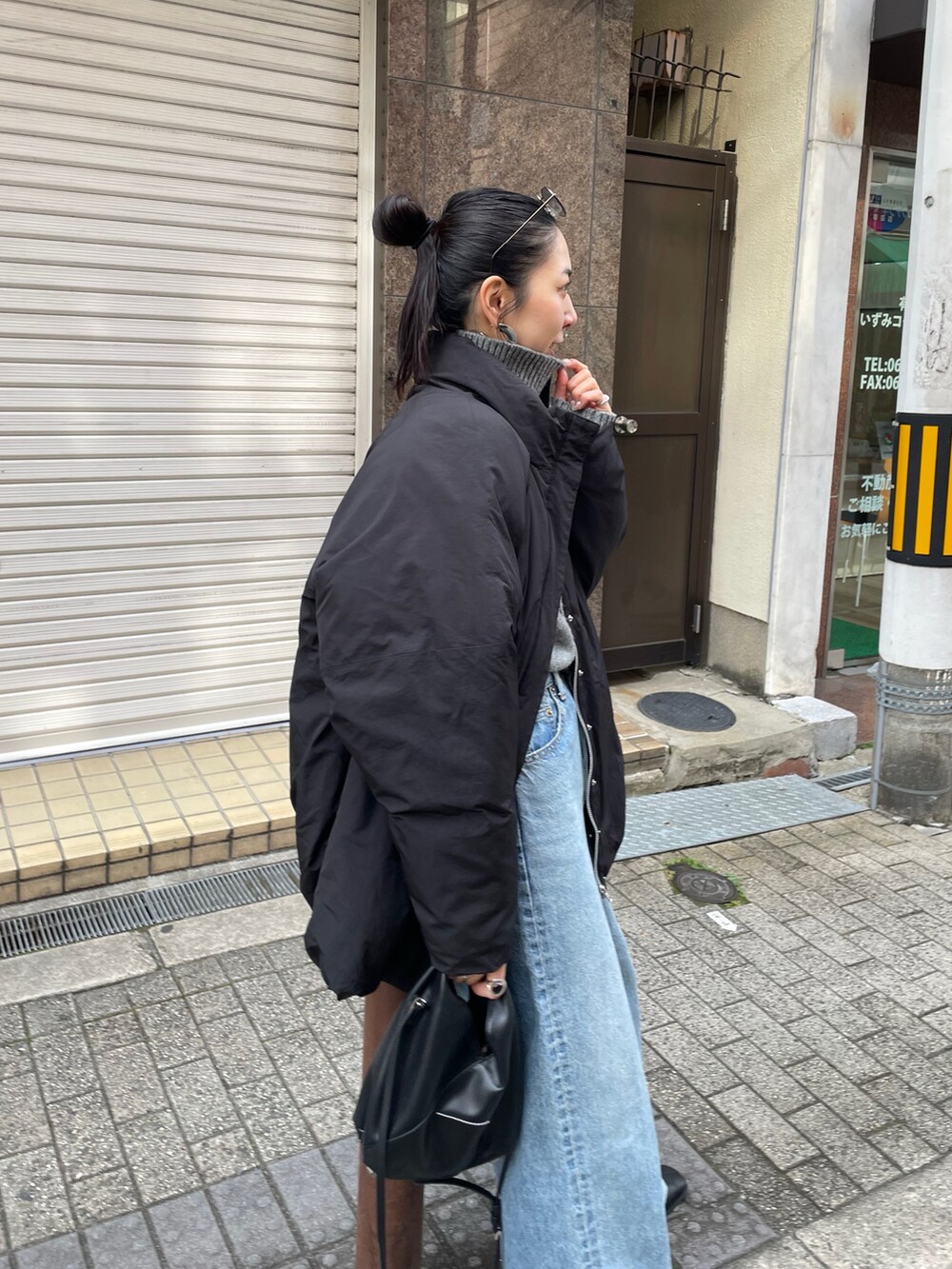 グレー系のニット/セーター、ブラック系のブルゾン、ブルー系のデニムパンツを着用したレディースの冬コーディネートの3枚目の写真