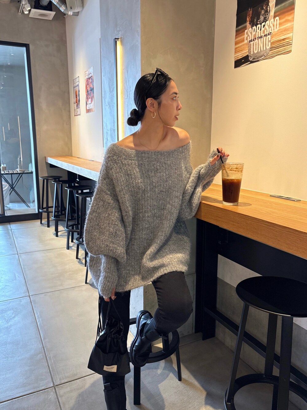 ブラック系のショルダーバッグ、ブラック系のブーツ、ブラック系のデニムパンツを着用したレディースの秋コーディネートの5枚目の写真