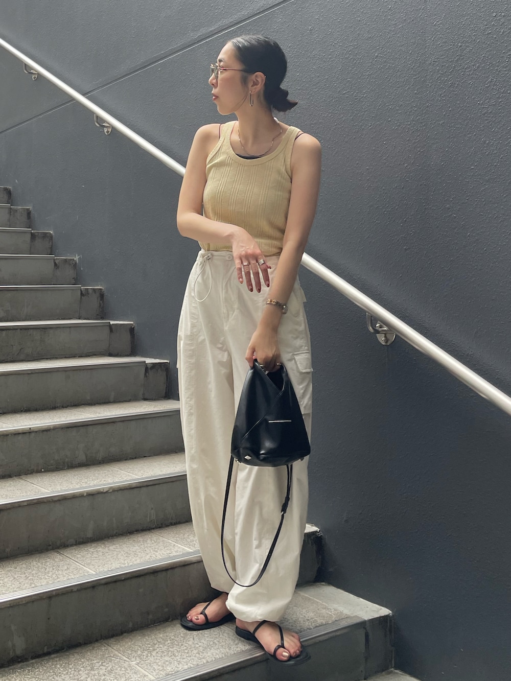 ホワイト系のカーゴパンツ、イエロー系のTシャツ/カットソー、ブラック系のショルダーバッグを着用したレディースの夏コーディネートの5枚目の写真