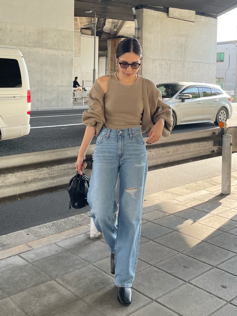 ベージュ系のカーディガン/ボレロ、ブラック系のハンドバッグ、ブラック系のブーツを着用したレディースの秋コーディネートの3枚目の写真