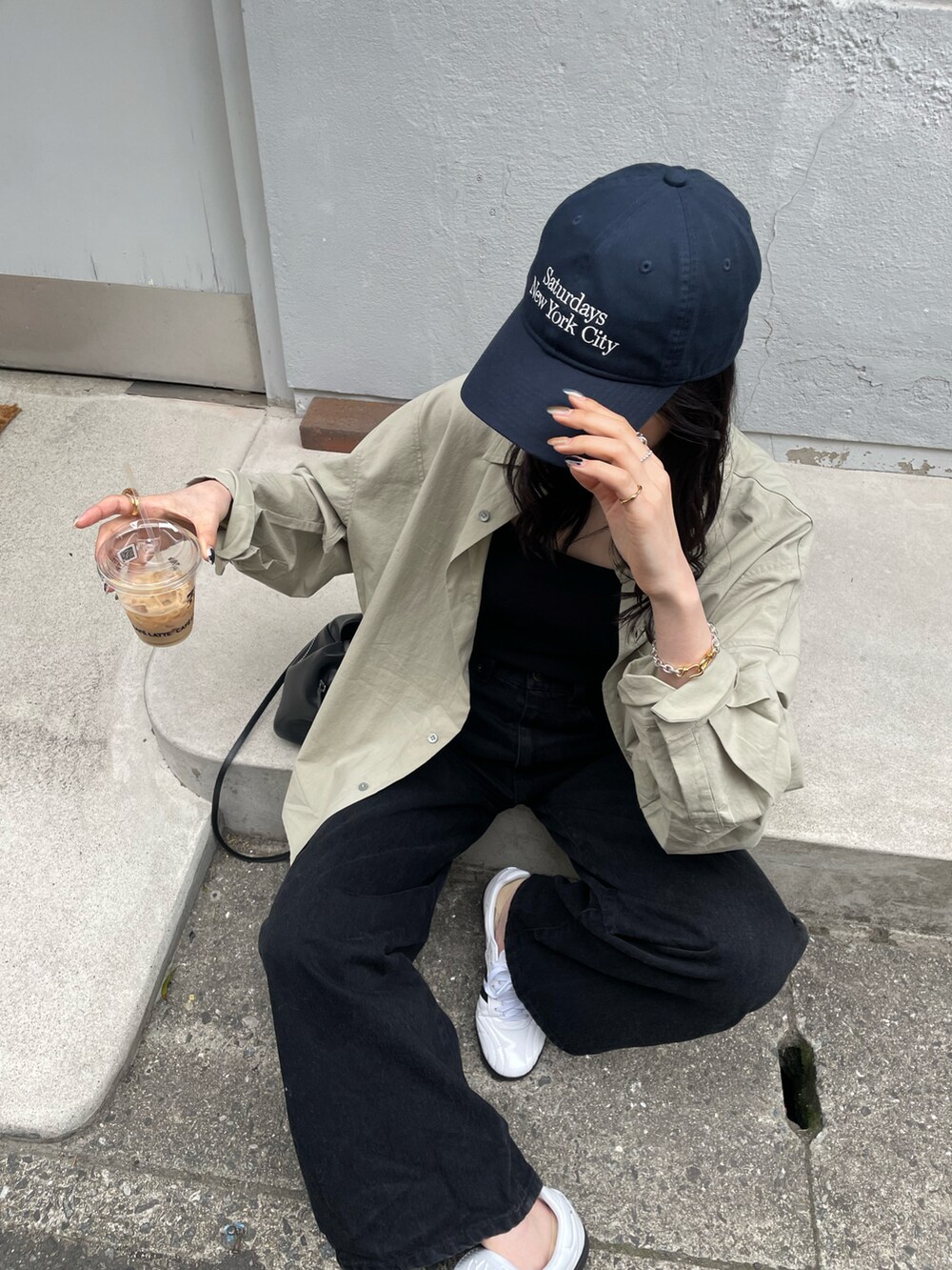 ホワイト系のスニーカー、ブラック系のショルダーバッグ、ブラック系のキャミソールを着用したレディースの春コーディネートの3枚目の写真