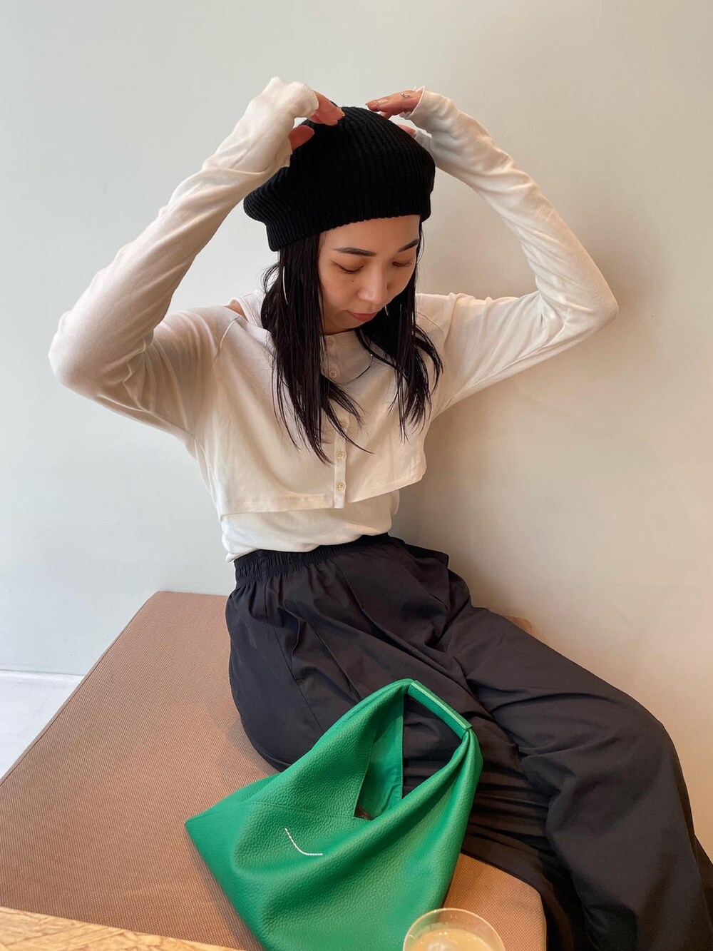 ゴールド系のパンプス、グリーン系のショルダーバッグ、ホワイト系のTシャツ/カットソーを着用したレディースの秋コーディネートの4枚目の写真