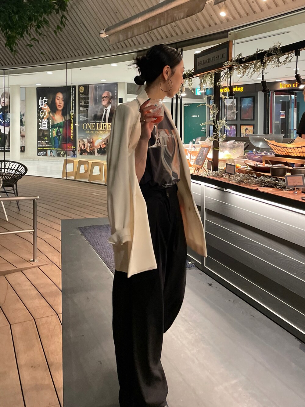 ブラック系のスラックス、ブラック系のサンダル、ホワイト系のテーラードジャケットを着用したレディースの夏コーディネートの3枚目の写真