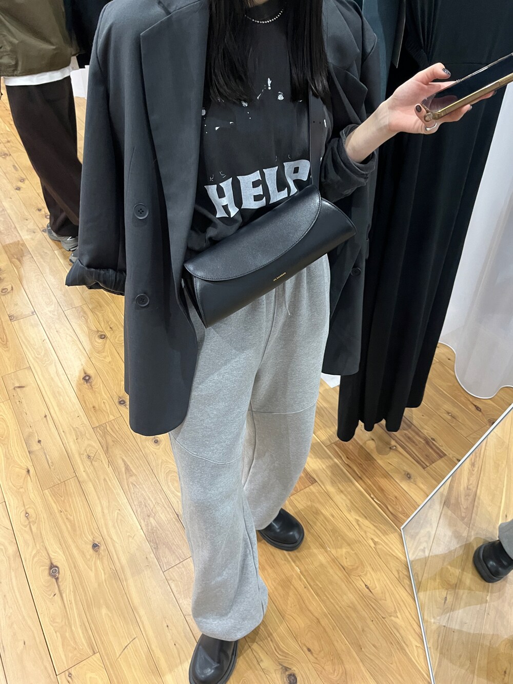 ブラック系のTシャツ/カットソー、ブラック系のショルダーバッグ、ブラック系のブーツを着用したレディースの秋コーディネートの2枚目の写真