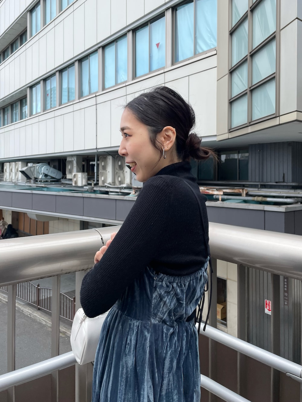 ホワイト系のハンドバッグ、ブルー系のワンピース、ブラック系のニット/セーターを着用したレディースの冬コーディネートの4枚目の写真