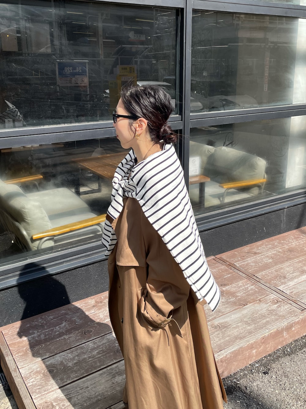 ゴールド系のパンプス、イエロー系のトレンチコート、ホワイト系のワンピースを着用したレディースの冬コーディネートの5枚目の写真