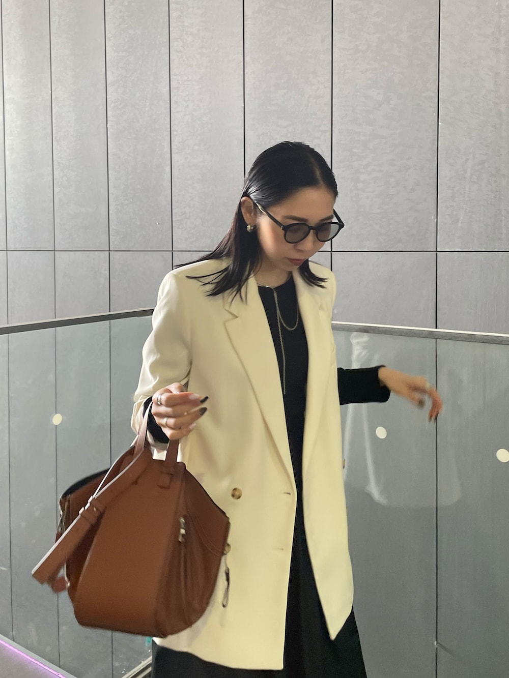 ブラウン系のバックパック/リュック、ゴールド系のパンプス、ブラック系のTシャツ/カットソーを着用したレディースの春コーディネートの5枚目の写真