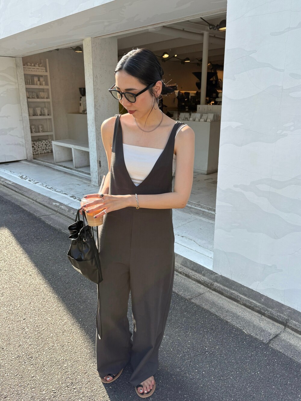 ブラック系のサンダル、ブラック系のショルダーバッグ、シルバー系のネックレスを着用したレディースの夏コーディネートの4枚目の写真