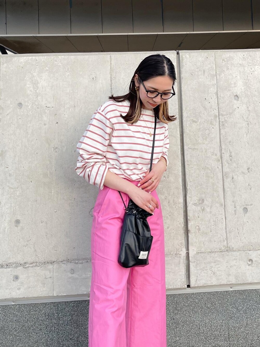 ピンク系のTシャツ/カットソー、ピンク系のスラックス、ブラック系のブーツを着用したレディースの冬コーディネートの3枚目の写真