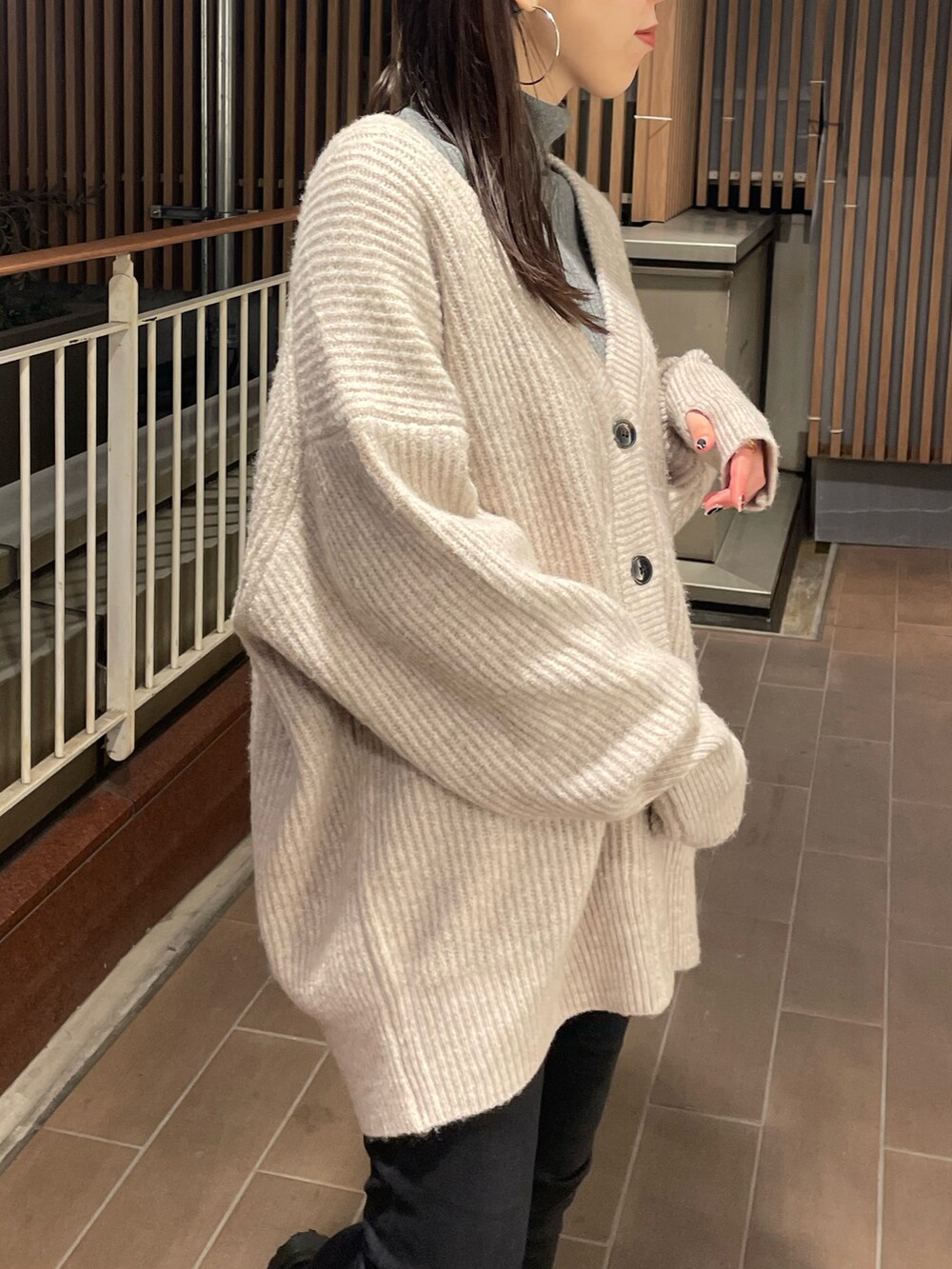 ホワイト系のカーディガン/ボレロ、ブラック系のデニムパンツ、ブラック系のブーツを着用したレディースの冬コーディネートの4枚目の写真