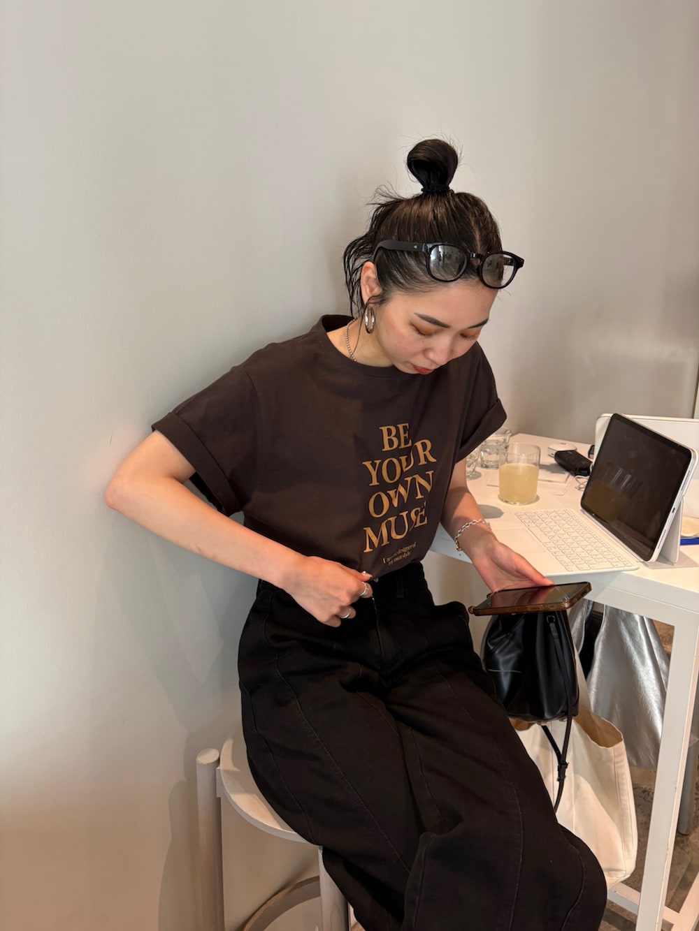 ブラック系のショルダーバッグ、ゴールド系のパンプス、シルバー系のネックレスを着用したレディースの春コーディネートの3枚目の写真