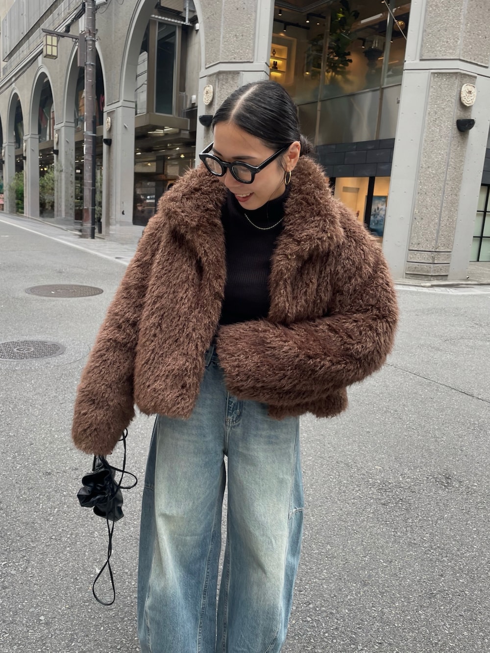 ブラック系のブーツ、ブラック系のショルダーバッグを着用したレディースの秋コーディネートの4枚目の写真