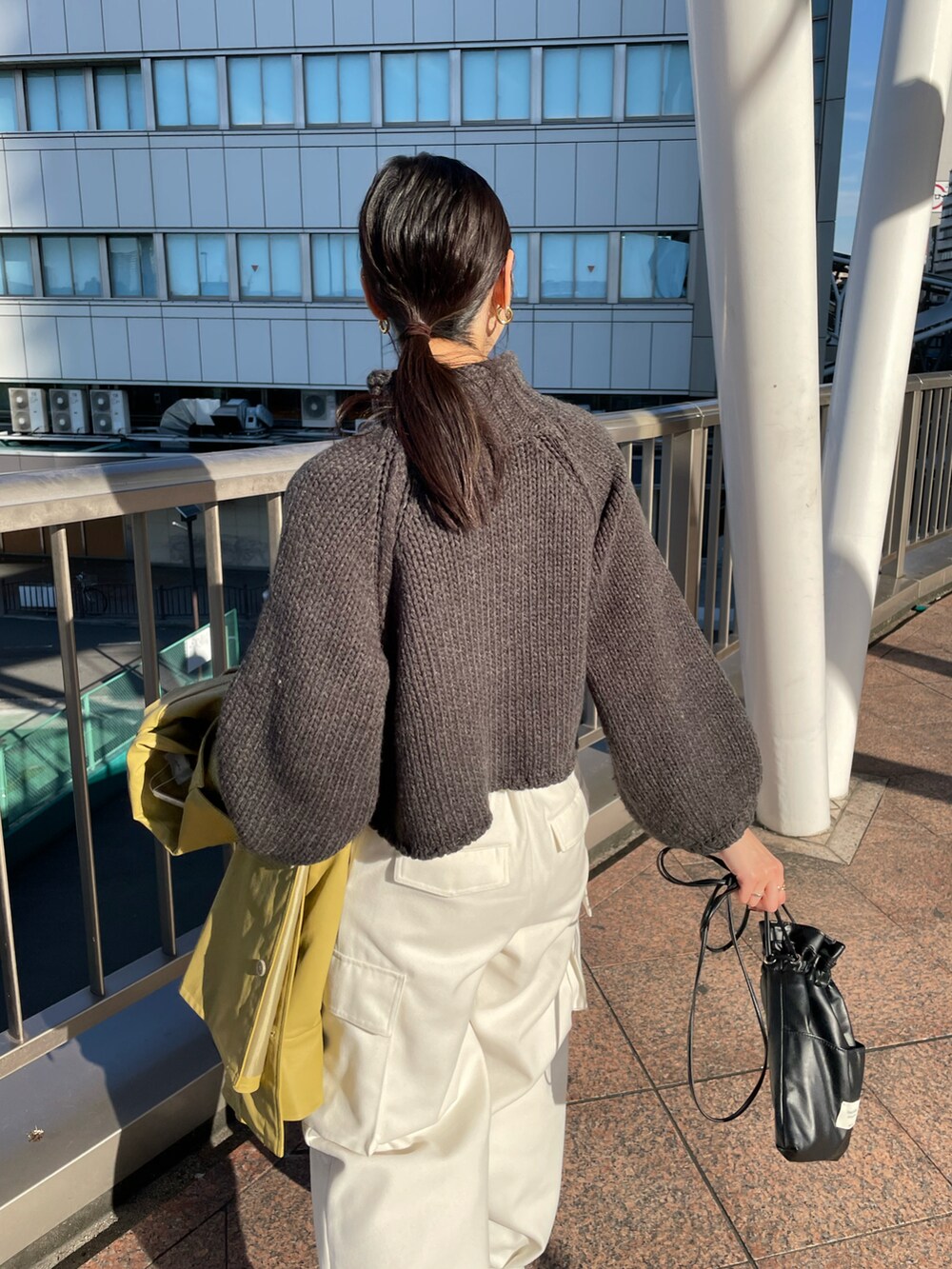 ブラック系のショルダーバッグ、ブラック系のブーツ、ホワイト系のカーゴパンツを着用したレディースの秋コーディネートの5枚目の写真