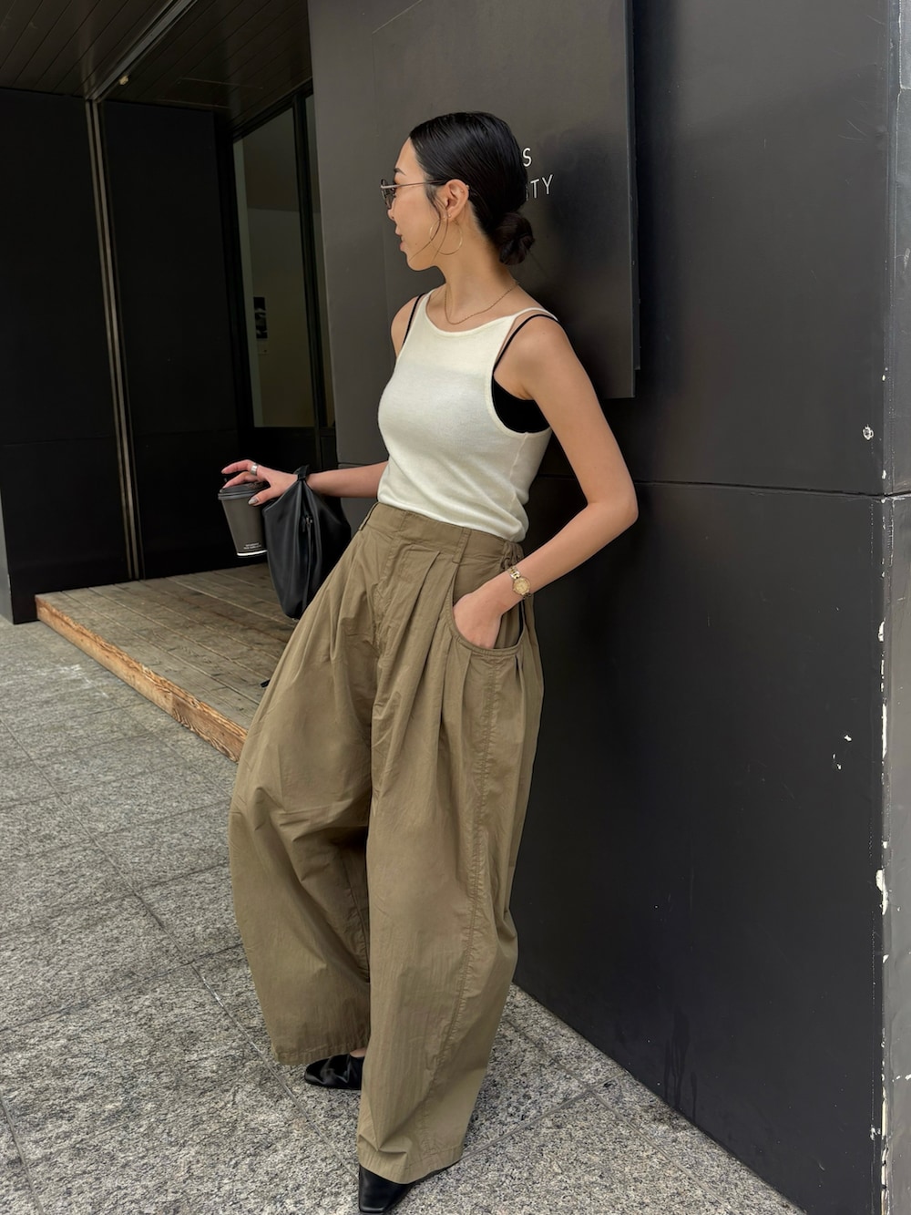 ブラック系のショルダーバッグ、ブラック系のサンダル、シルバー系のピアス（両耳用）を着用したレディースの春コーディネートの4枚目の写真