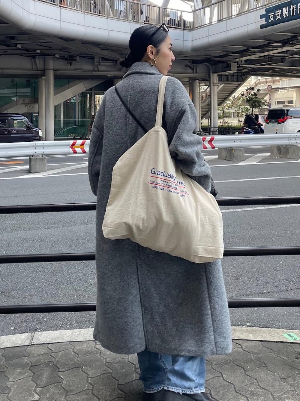 ブラック系のブーツ、ブルー系のデニムパンツ、ブラック系のショルダーバッグを着用したレディースの冬コーディネートの4枚目の写真