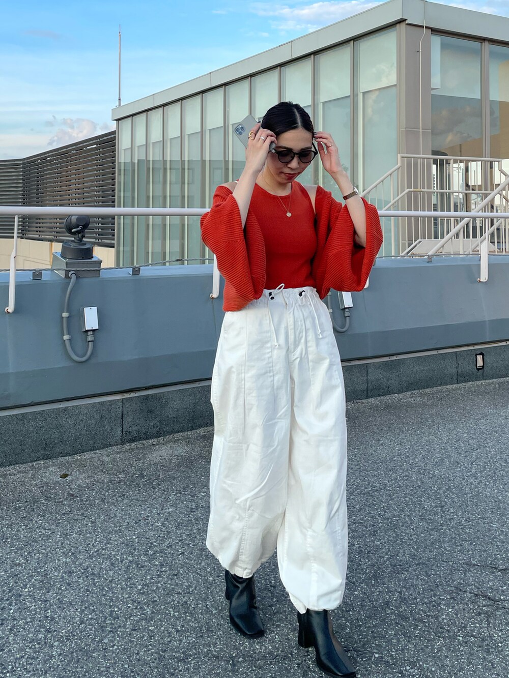 オレンジ系のカーディガン/ボレロ、ホワイト系のその他パンツ、ブラック系のブーツを着用したレディースの秋コーディネートの3枚目の写真