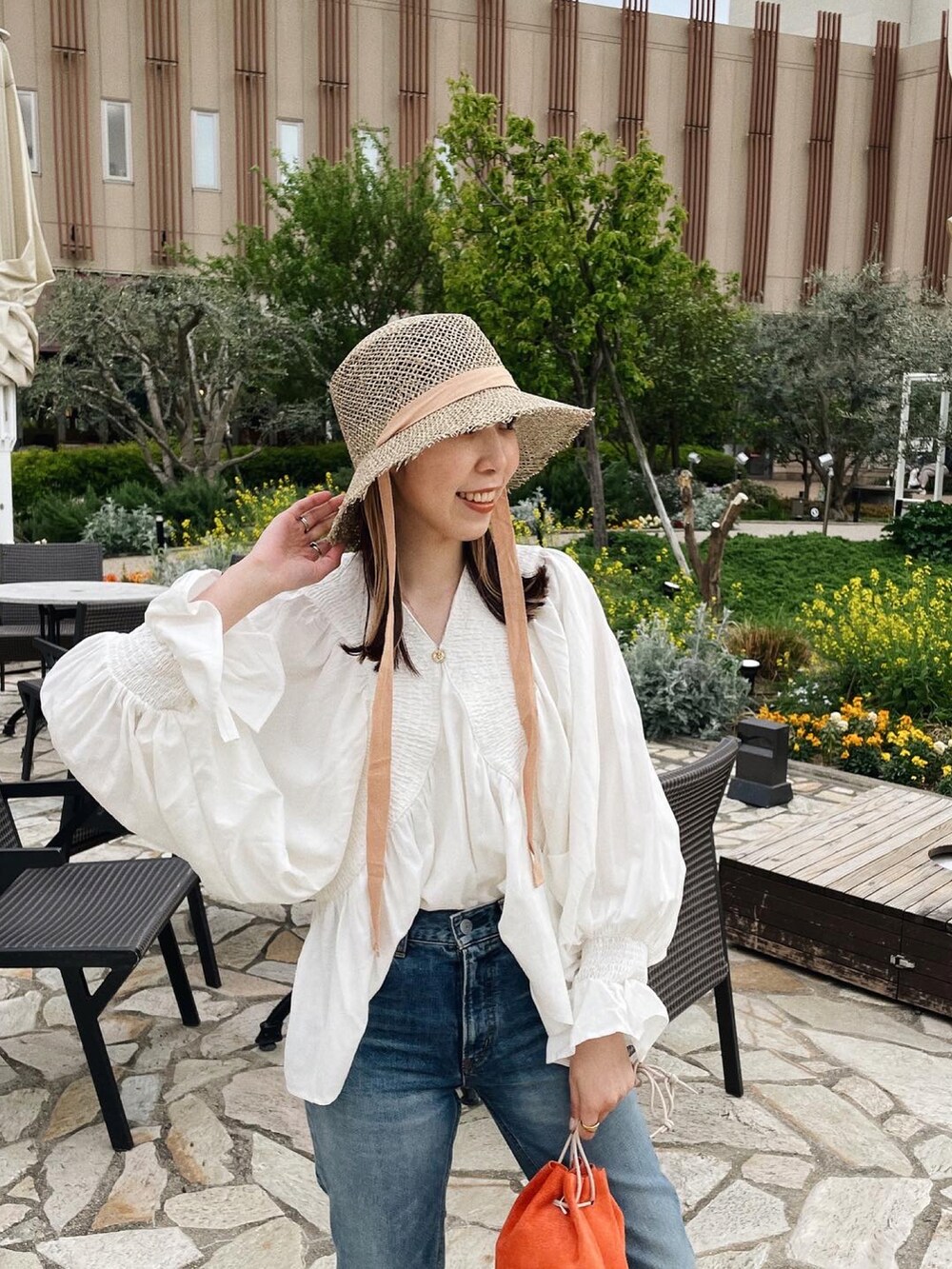 ホワイト系のシャツ/ブラウス、ブルー系のデニムパンツ、ブラック系のサンダルを着用したレディースの春コーディネートの3枚目の写真