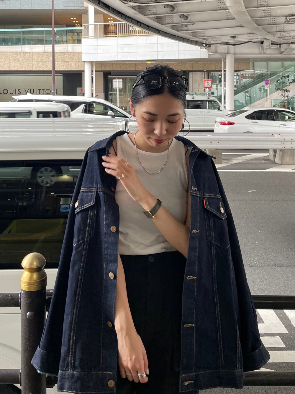 ブルー系のデニムジャケット、ブラック系のカーゴパンツ、ブラック系のサンダルを着用したレディースの夏コーディネートの4枚目の写真